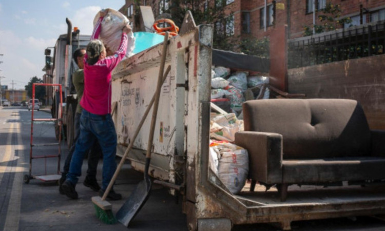 Foto que muestra personas dejando residuos en una volqueta 
