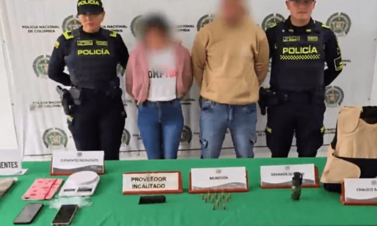 Dos personas capturadas en medio de dos policías. 