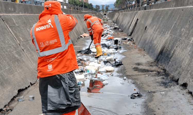 Foto que muestra personas limpiando un canal de agua 