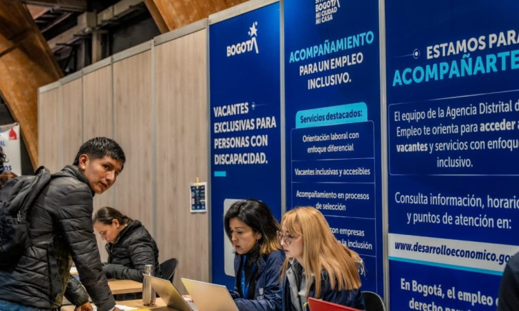 Participante en la Megaferia de Empleo junto a funcionarias de la Alcaldía de Bogotá
