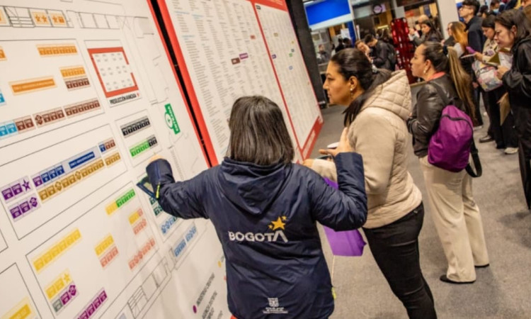 Funcionaria de la Alcaldía de Bogotá guiando a participante de la Meferia de Empleo
