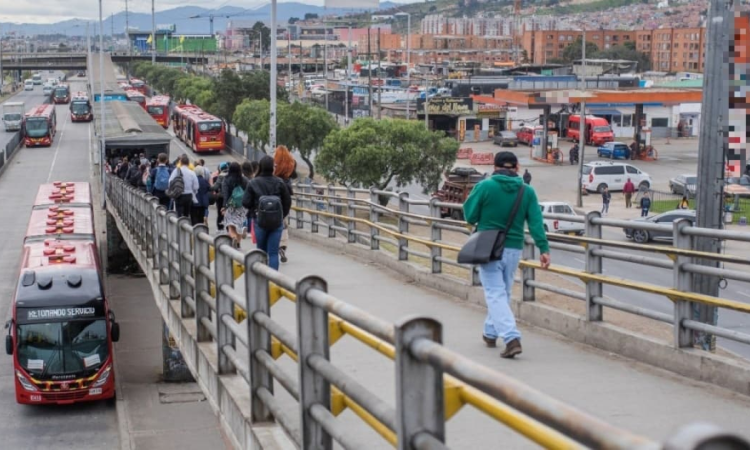 Foto de una calle de la ciudad de Bogotá donde se ven personas y buses