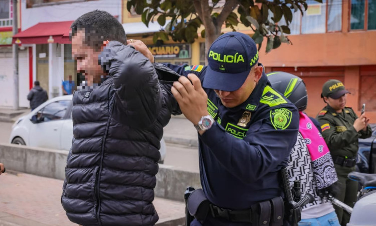 Foto de un uniformado de la Policía de Bogotá requisando a una persona durante la intervención en el parque Bellavista de Kennedy en Bogotá.