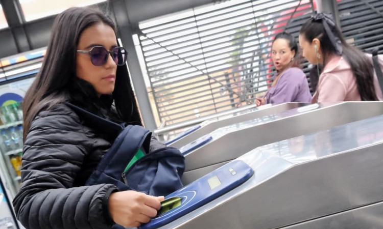 Foto de una mujer accediendo a una estación de TransMilenio en Bogotá.