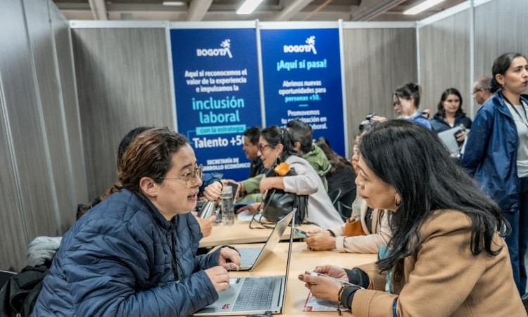 Ciudadana en una feria de empleo en Bogotá junto a una funcionaria de la Secretaría Distrital del Desarrollo Económico