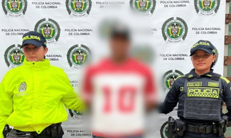 Foto de un hombre capturado en medio de dos policías.