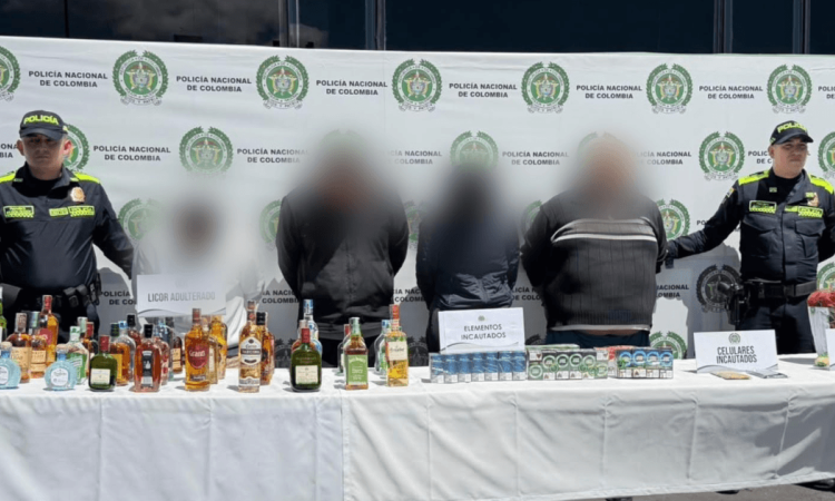 Cuatro de los seis capturados, junto a los elementos incautados, en medio de dos policías.
