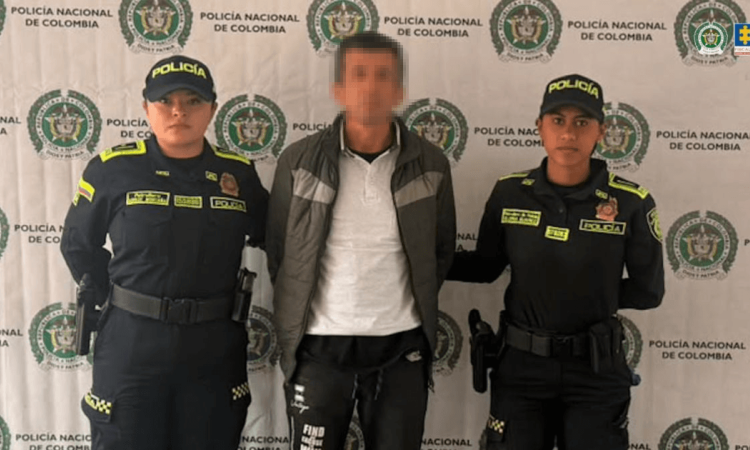 Foto de hombre capturado en medio de dos policías.