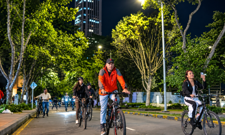 Imagen de varias personas transitando por una vía de Bogotá en su bicileta en la ciclovía nocturna.