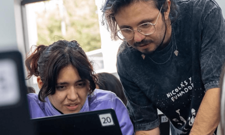 Una mujer y un hombre mirando la pantalla de un computador.
