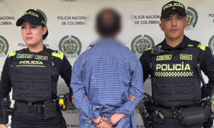 Foto de una persona capturada junto a dos policías