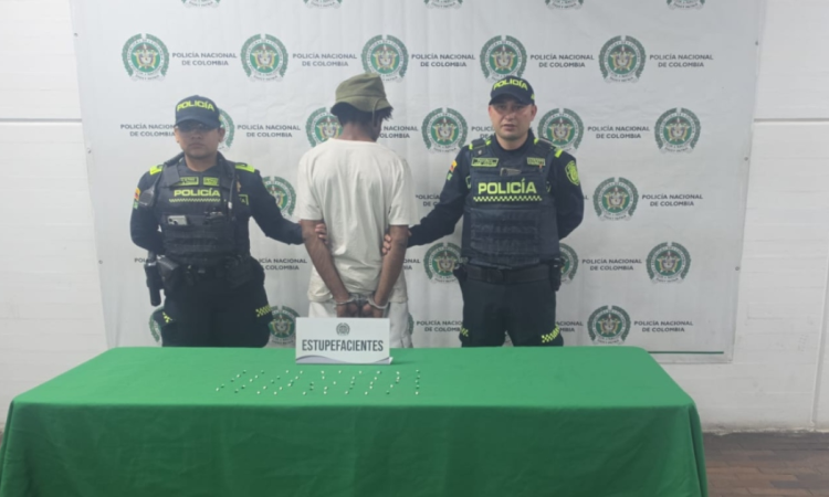 Foto que muestra dos policías y un capturado 