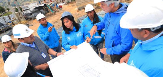 El Alcade Enrique Peñalosa con varios ingenieros en una obra de la ciudad, observando planos de construcción 
