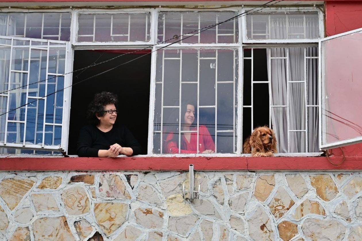 Personas en una ventana con su perro.
