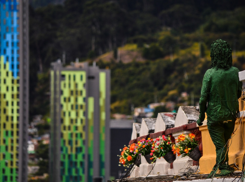 Imagen panorámica de la ciudad con flores y una obra de arte en primer plano.