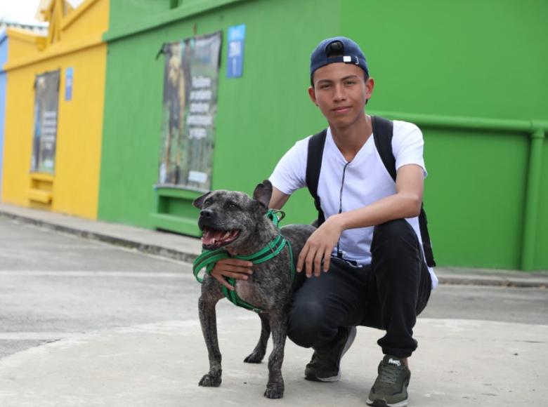 Joven con su nuevo amigo peludo, demostrando que Bogotá es amiga de los animales.