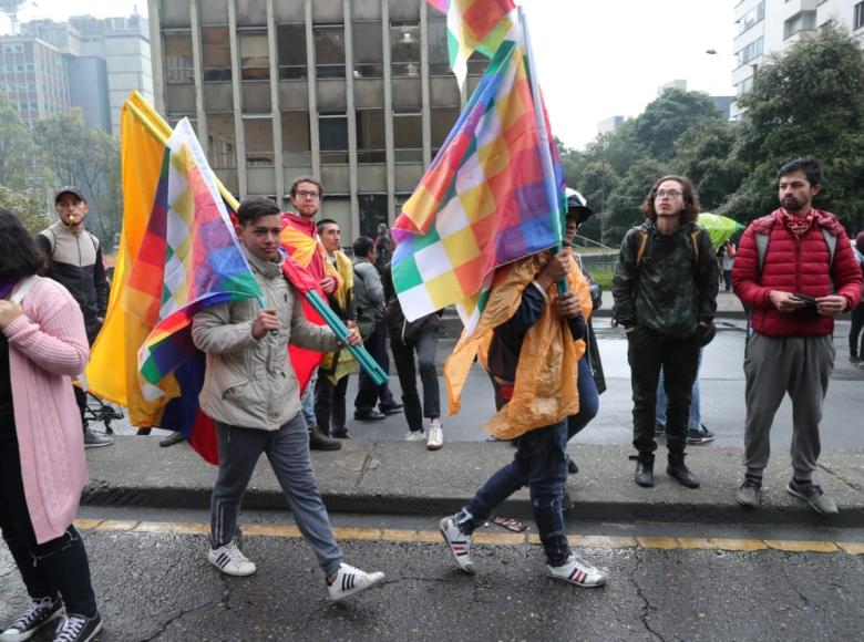 Ciudadanos cargando las banderas del movimiento indígena