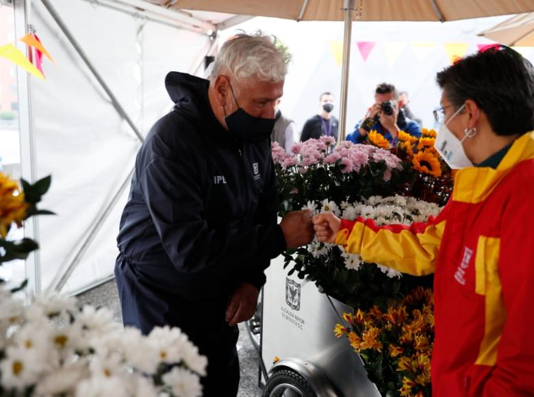 Claudia López saluda a vendedor informal de flores beneficiario de uno de los triciclos que entregó el IPES 