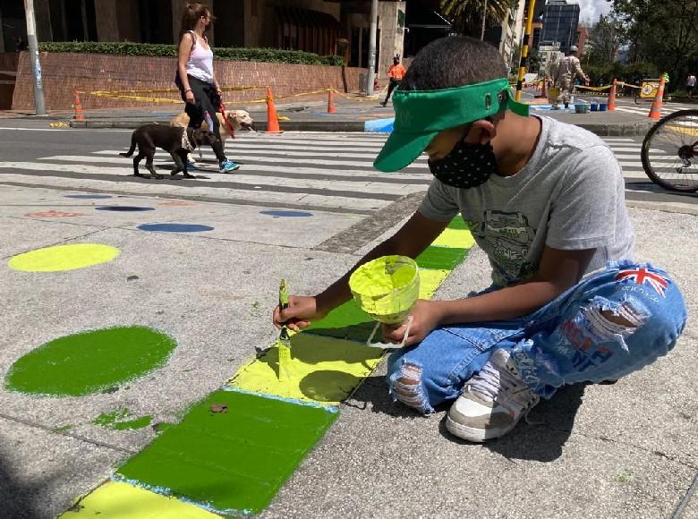 Persona pintando un paso peatonal.