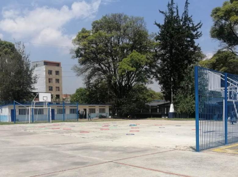 Antes: La cancha escolar ubicada en el centro del colegio era un espacio pequeño para las y los estudiantes. El espacio requería mejoras en el piso y cambio de canchas. 