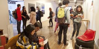 Varias personas mirando alrededor de las obras de la galería 