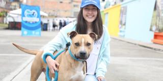 Voluntario de protección animal posando con perro. 