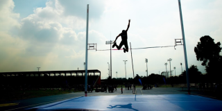 Hombre practica salto con garrocha.