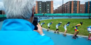 Imagen de Enrique Peñalosa tomando foto con su celular a patinadores en San Ignacio del Tintal