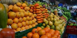 Una foto de varias frutas, granadillas, naranjas, mandarinas exhibidas en la plaza de mercado