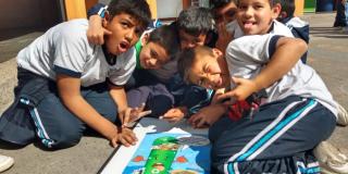 Cinco niños abrazados jugando un juego en el patio del colegio
