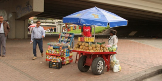 Dos carritos coloridos con productos comestibles y frutas sobre un andén.