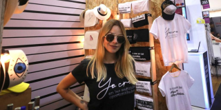 Actriz y activista Johana Bahamón posa en el stand de Buró con camisetas y sombreros fabricados por personas privadas de la libertad. 