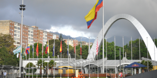 Entrada principal a Corferias en el marco de una feria con el tradicional arco y banderas de varios países, incluida la de Colombia.
