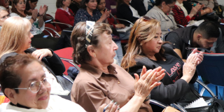Mujeres bogotanas escuchan una conferencia, ellas serían las beneficiadas de la reducción de homicidios en Bogotá.