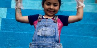 Niña feliz pintando las escaleras del barrio Bella Flor en Ciudad Bolívar 