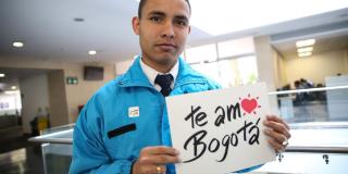 Imagen de un funcionario del Distrito con letrero de Te amo Bogotá