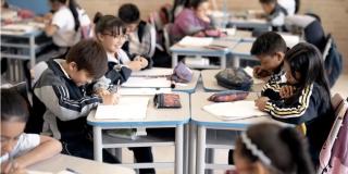 Imagen de estudiantes escribiendo en sus cuadernos 