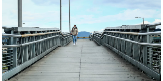 Fotografía de una persona caminando en un puente peatonal.