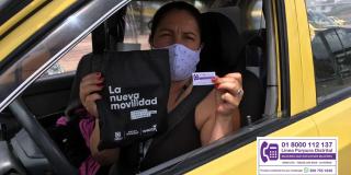 Mujer taxista recibiendo el sticker de la Línea Púrpura.