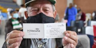 Imagen de un adulto mayor con su carnet de vacunación.
