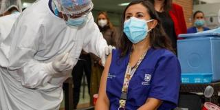 Imagen de una funcionaria en salud recibiendo la vacuna.