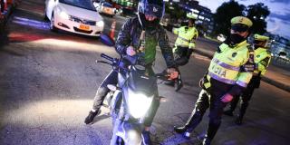 Motociclista junto a policía de tránsito.
