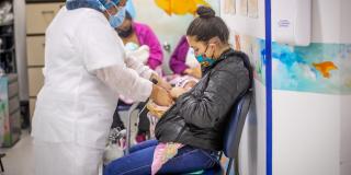 Enfermera atendiendo a mamá y su bebé