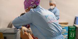 Imagen de una mujer recibiendo la vacuna contra COVID-19. 