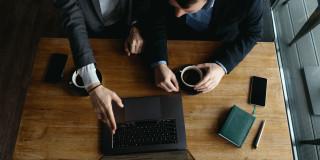Dos hombres frente a un computador