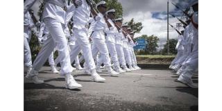 Desfile de militares con uniforme blanco