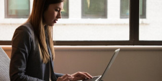 Mujer frente a un computador (Banco de imágenes)