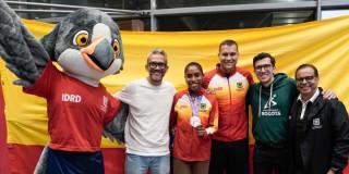 Deportista de Bogotá recibiendo reconocimiento por parte de directivos y mascota oficial 