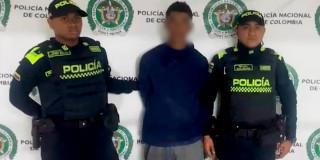Imagen de un hombre detenido junto a dos policías.