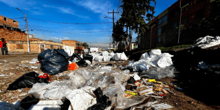 Foto de una calle llena de escombros y basuras